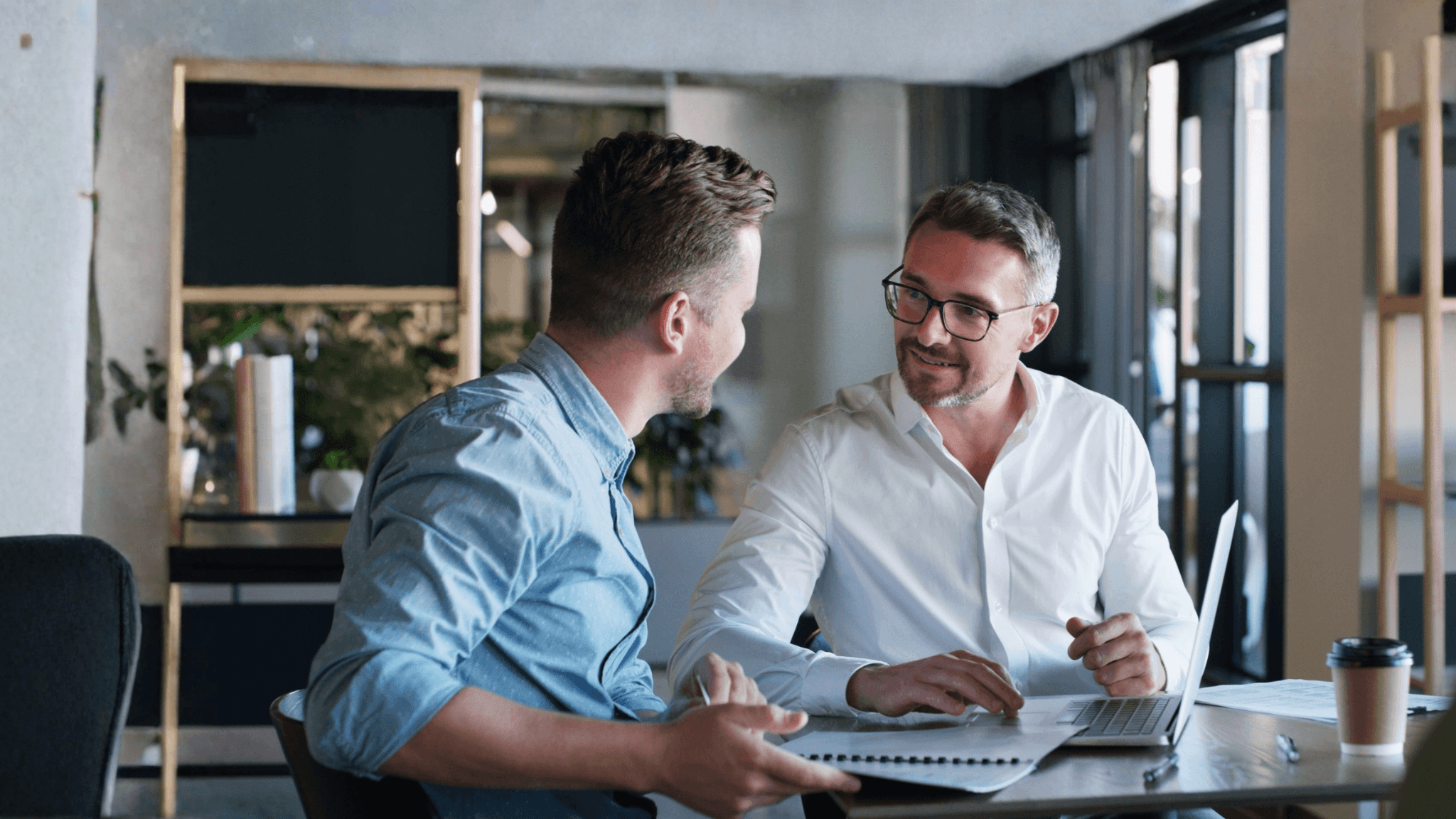 Two men in dress shirts at a coffee shop