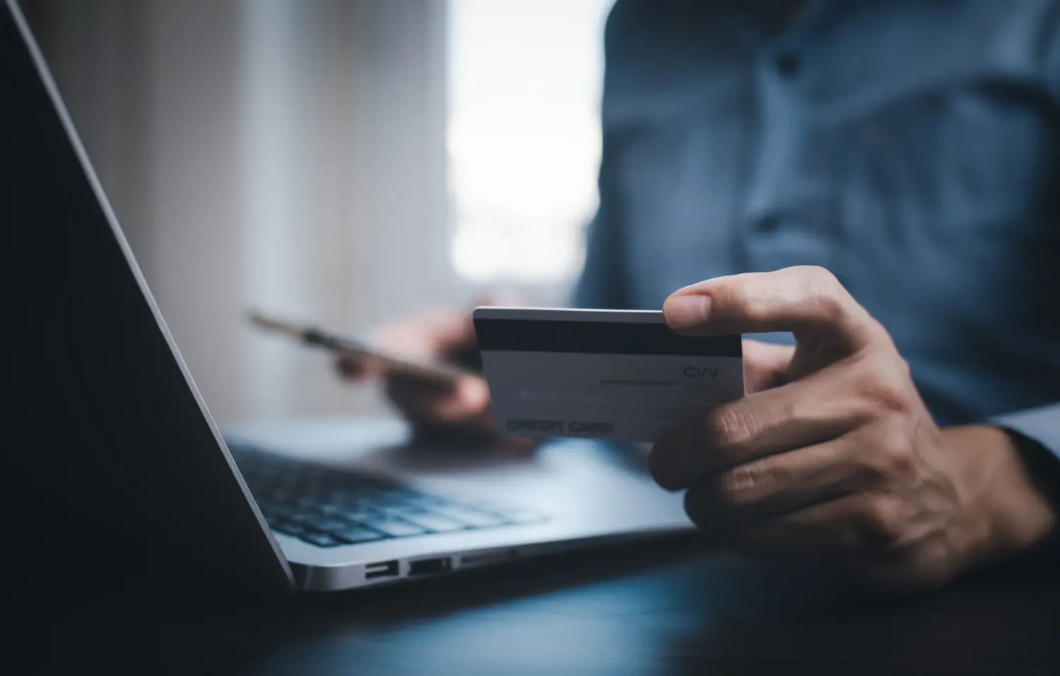 hand-holding-credit-card-makes-purchase-internet-laptop-computer-with-credit-card-online-payment-shopping-online-ecommerce-internet-banking-spending-money-concept
