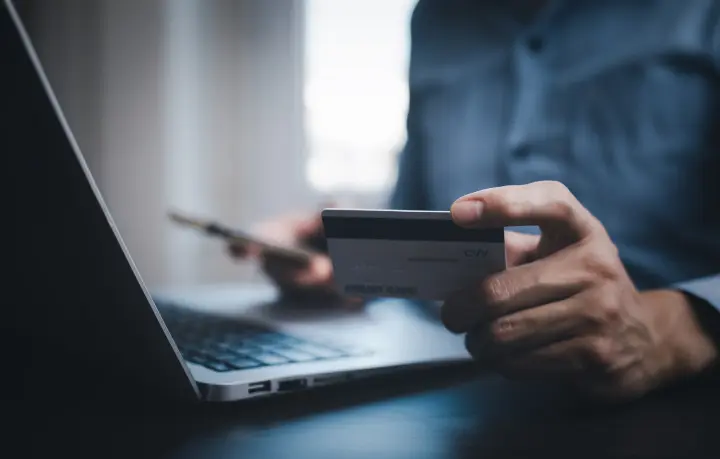 hand-holding-credit-card-makes-purchase-internet-laptop-computer-with-credit-card-online-payment-shopping-online-ecommerce-internet-banking-spending-money-concept